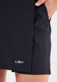 Marina blå shorts tillverkade av lättviktsmaterial, med en sidoficka och en liten vit CMP-logotyp nära fållen. Slät textur och skräddarsydd passform.