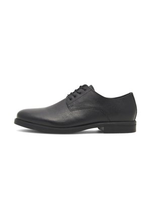 Zapato formal de vestir de cuero negro con punta redonda, cierre con cordones en la parte delantera y tacón bajo apilado, mostrado de perfil sobre fondo blanco.