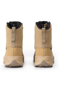 Botas de tobillo impermeables marrones con una parte superior de ante texturizado, suela de goma robusta y dos correas grises en la parte posterior para facilitar su uso.