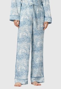 Siniset ja valkoiset kuviolliset pyjamasait ovat kevyttä kangasta. Niissä on naru vyötäröllä, leveät lahkeet ja kontrastivärinen sininen reunus.