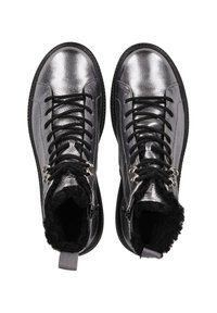 Ein Paar metallic silberne Schnürstiefel mit schwarzem Kunstfellfutter und seitlichem Reißverschluss, von oben auf einem weißen Hintergrund betrachtet.