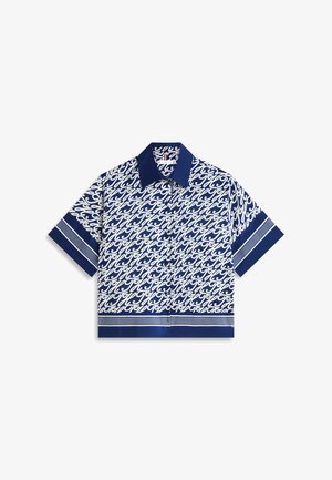 Chemise bleu marine à manches courtes avec boutons, motif répétitif en écriture cursive blanche, et col, poignets, ainsi que bandes d'ourlet bleu marine unis.