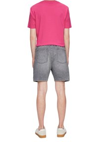 Szare dżinsowe szorty o luźnym kroju, zestawione z jasnoróżową bawełnianą koszulą. Zawierają standardowe tylne kieszenie oraz subtelne detale stębnowania.