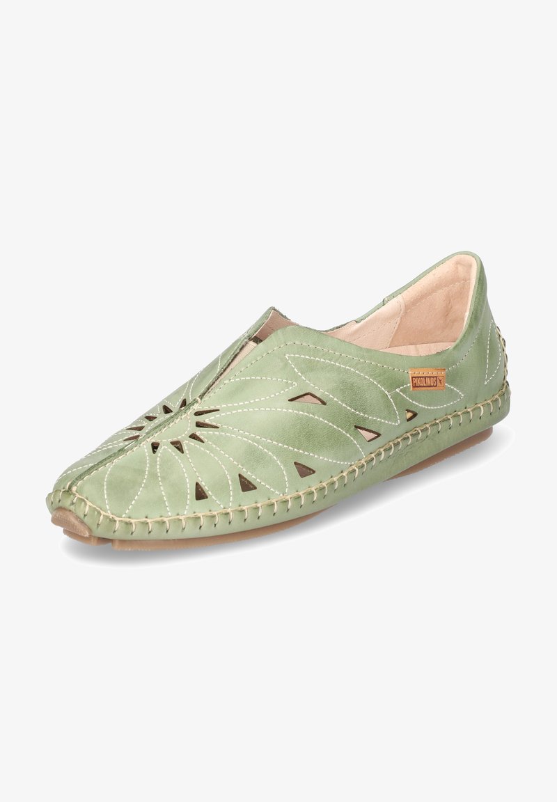 Chaussure en cuir vert avec des motifs floraux découpés, des coutures autour des bords et une semelle plate. Présente une doublure intérieure beige et une étiquette de marque.