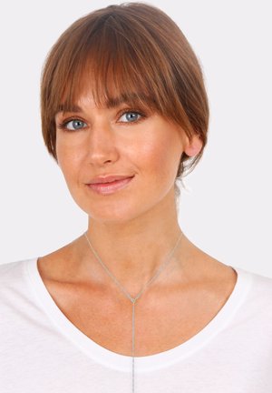 Silver chain necklace with a Y-shaped design, featuring a central drop and fine links, worn by a person in a white t-shirt.