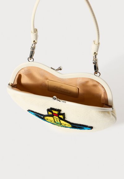 Malá biela kabelka s krátkym rukojetí, zdobená vyšívaným farebným logom a vnútornou podšívkou hnedej farby s dizajnérskou značkou.