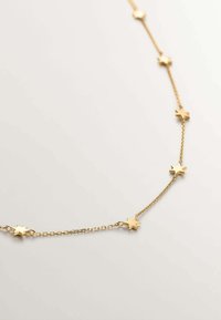 Collar de cadena dorada con eslabones en forma de estrella, espaciados uniformemente a lo largo de la cadena, con un acabado suave y una textura delicada.