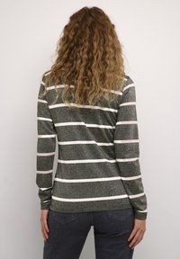 Maglietta a maniche lunghe con righe orizzontali verdi e bianche, caratterizzata da una sottile texture glitterata. Progettata con una silhouette aderente e scollatura rotonda.