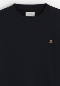 Námorně modrá mikina vyrobená z bavlny. Obsahuje kulatý výstřih a malé žluté logo lebky a zkřížených kostí na levé straně hrudi.