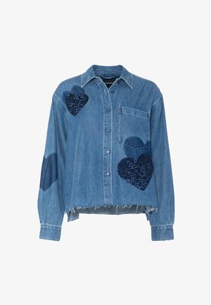 Džínová košile s límečkem, zdobená třemi tmavě modrými flitrovými nášivkami ve tvaru srdce. Světle modrá látka, krátká délka a třepený lem.