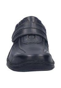 Zwarte leren schoen met een ronde neus, twee verstelbare klittenbandsluitingen, contrasterende stiksels en een gestructureerde rubberen zool.