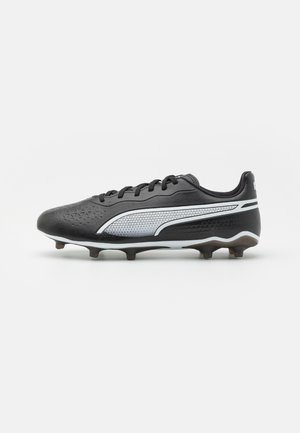 Scarpa da calcio nera con tomaia sintetica, design testurizzato, dettagli argentati e tacchetti neri sulla suola per la trazione. Lacci nella parte anteriore.