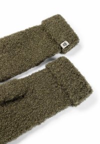 Grüne wollene Handgelenkwärmer mit einer strukturierten, flauschigen Oberfläche und einem kleinen Etikett mit einem Logo an einem Ende.