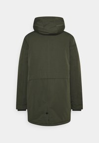 Grön huva jacka med hög krage, med rak passform, slät textur och sömdetaljer. Inga synliga knäppningar eller fickor.