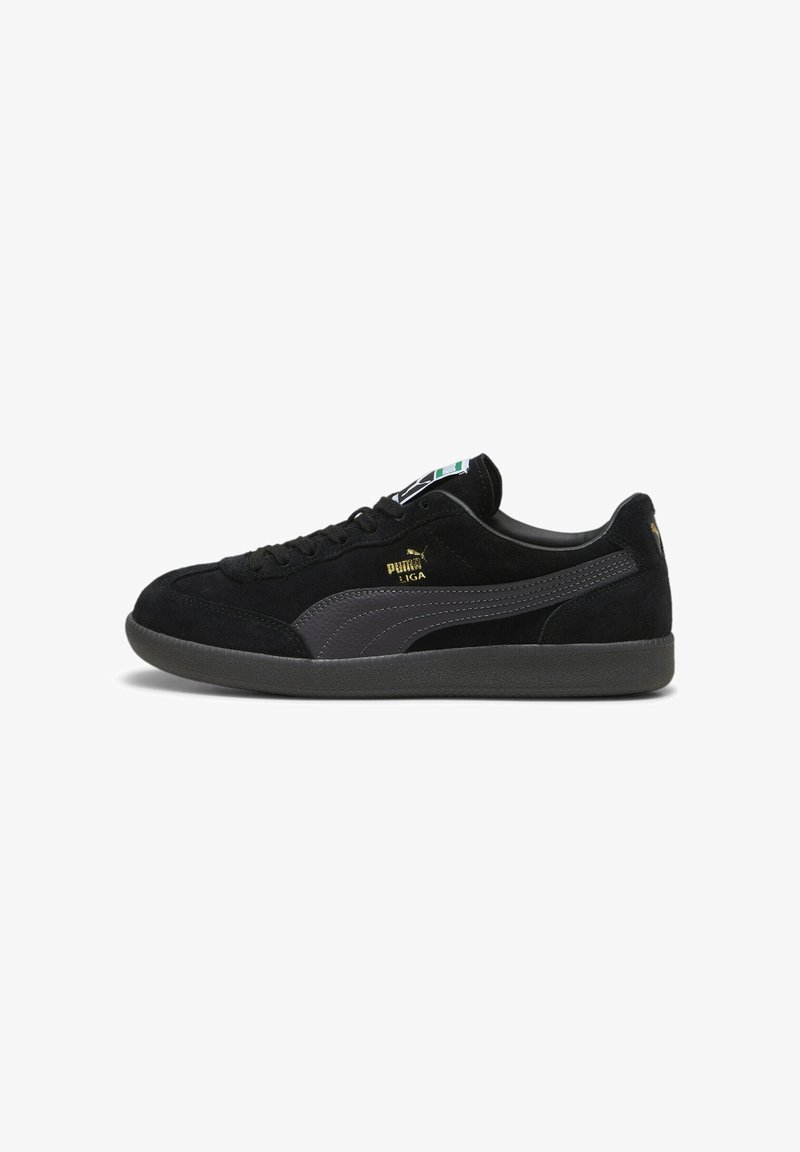 Baskets basses Puma en daim noir avec une bande gris foncé, une semelle noire et un logo "Puma Liga" doré sur le côté, vues de profil gauche.