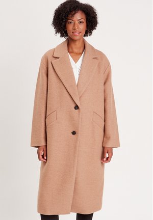 Beige Wollmischungsjacke mit Reverskragen, Doppelknopfverschluss und seitlichen Taschen. Übergrößenfit, strukturierter Stoff und lange Ärmel.