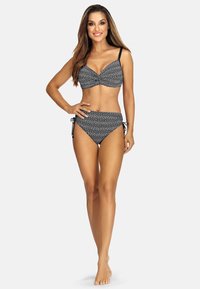 Czarny i biały kostium kąpielowy w wzory, z wkładką w górnej części i wiązanym dołem. Gładki materiał, regulowane ramiączka oraz geometryczny wzór.