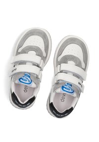 Witte en grijze sportieve schoenen met klittenbandsluitingen, gemaakt van suède en synthetische materialen, met een ronde neus en een zwarte hielaccent.