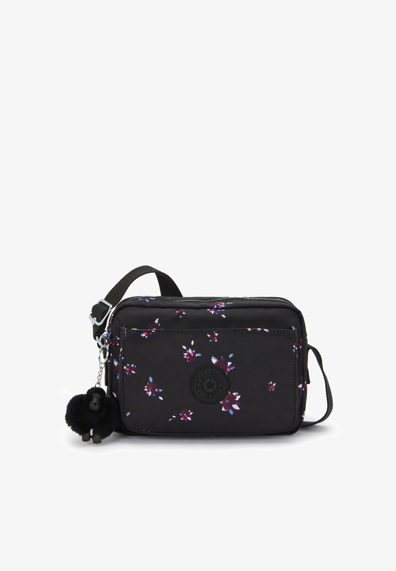 Borsa a tracolla nera con un piccolo motivo floreale viola e bianco, tasca frontale con zip e un portachiavi a forma di scimmietta nera e pelosa attaccato.