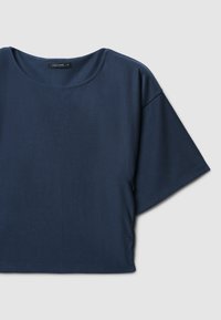Top corto blu navy con scollatura rotonda e maniche corte e larghe. Realizzato in un tessuto morbido, presenta un design semplice e minimale.