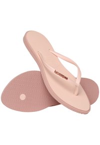 Light pink rubber flip-flops with textured footbed, thin straps, and branded logo. The sole features a diamond pattern for traction.