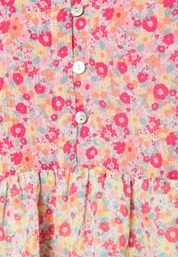 Robe boutonnée à fleurs avec un imprimé pastel multicolore de fleurs roses et orange, tissu texturé et un volant rassemblé en bas.