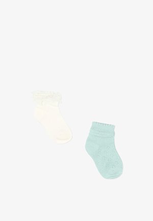 Deux petites chaussettes pour bébé, l'une crème avec un bord volanté, l'autre bleu clair avec un motif tricoté, sur un fond blanc.