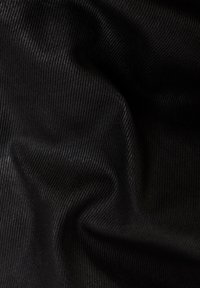 Černá tkanina s texturovaným, žebrovaným vzorem. Materiál vypadá hladce a mírně leskle, s jemnými záhyby, které vytvářejí plynulý vzhled.