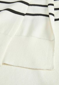 Suéter blanco de punto con rayas horizontales negras, puños acanalados y una textura suave. El diseño incluye un dobladillo recto.