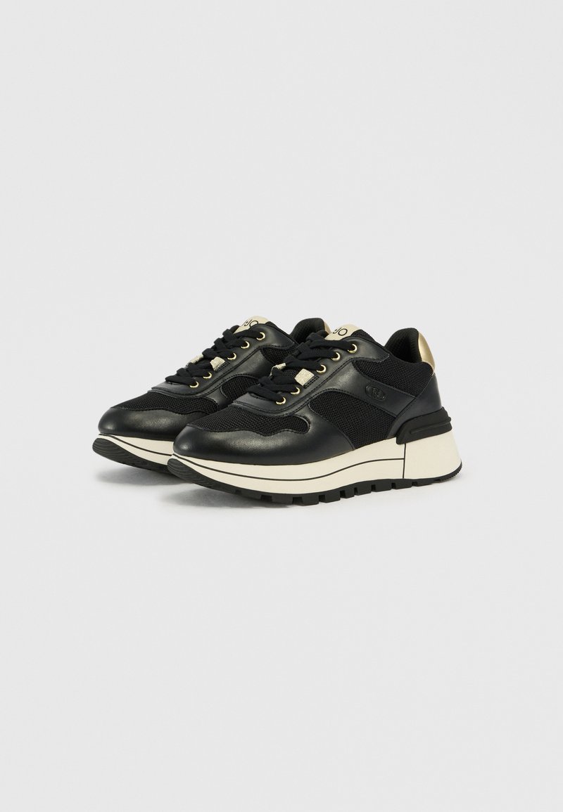 Schwarze sportliche Sneakers mit Leder- und Mesh-Bereichen, goldenen Akzenten, runder Zehenpartie, dickem weißen Zwischensohle und strukturiertem schwarzem Gummiaussensohle.