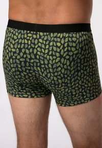 Pantaloni boxer neri con un motivo a foglia verde, tessuto morbido e un elastico nero con la scritta "JP1880" ricamata in modo discreto.