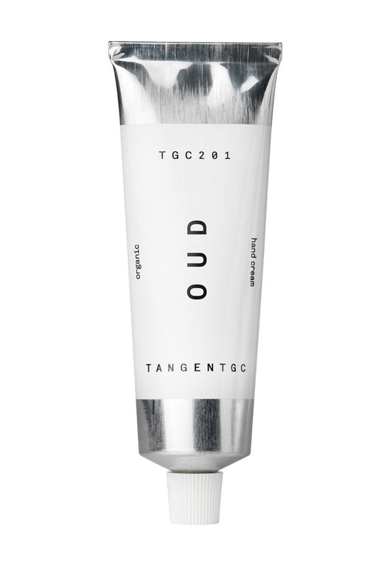 Tubo di metallo bianco con cappuccio silver, etichettato "OUD" e "TANGENTGC", indicante crema per mani biologica. Texture liscia, design minimalista.