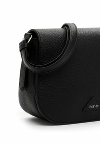Schwarze Schultertasche aus strukturiertem Leder mit geschwungener Klappe, verstellbarem Riemen und kleinem dreieckigem Logopatch mit der Aufschrift "RUE 09."