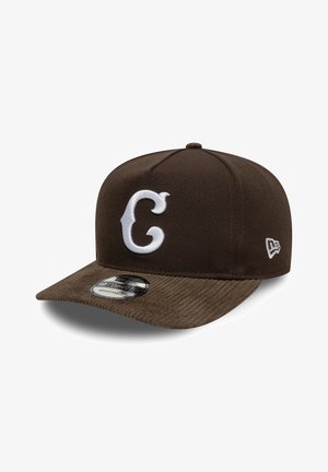 Bruine verstelbare baseballpet met wit gestileerd "C"-logo aan de voorkant en New Era-logo aan de zijkant, zichtbare corduroy randstructuur.