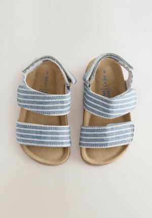 Sandales rayées bleues et blanches avec deux sangles velcro ajustables, une semelle rembourrée beige et une semelle durable.