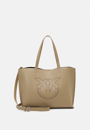 Sac cabas en cuir beige avec deux poignées, une bandoulière amovible et un motif perforé de deux oiseaux se faisant face à l'avant.