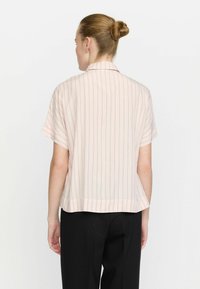 Short-sleeve shirt in light pink with vertical stripes in orange and blue. Loose fit, soft texture, collared design, and longer back hem.
