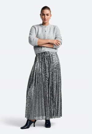 Gray knitted cardigan with round neckline, silver sequin pleated maxi skirt, and black heeled booties. Simple earrings complete the look.