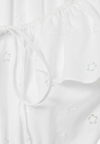 Vêtement blanc avec des motifs floraux brodés. Présente un encolure froncée avec cordon de serrage et une texture de tissu douce et légère.