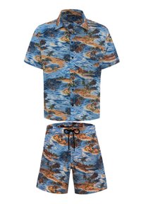 Camicia a maniche corte con bottoni e pantaloni corti coordinati, entrambi con una stampa tropicale blu che presenta isole, palme e fiori in colori vivaci.
