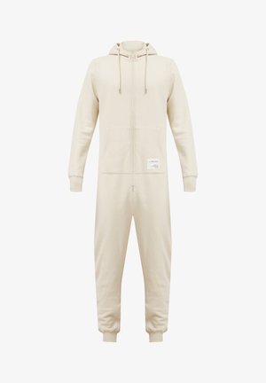 Beige hooded zip-up onesie made of soft fabric, featuring a front pocket and drawstrings. Includes a label on the lower left side.