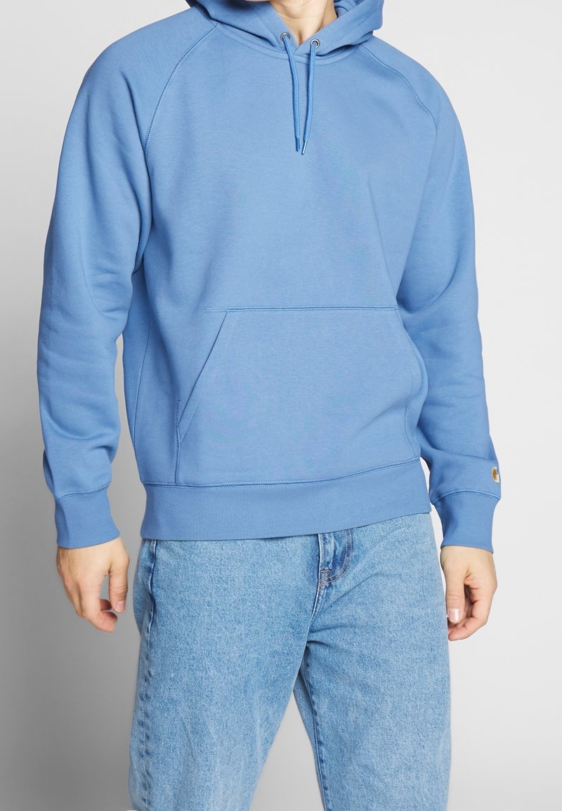 Sudadera azul con capucha ajustable, bolsillo canguro y puños de canalé. Hecha de una tela suave, presenta un corte relajado y un detalle de logo.