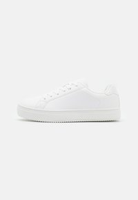 Zapatilla blanca con parte superior sintética lisa, perfil bajo, puntera redondeada, cinco agujeros para cordones y suela de goma texturizada.
