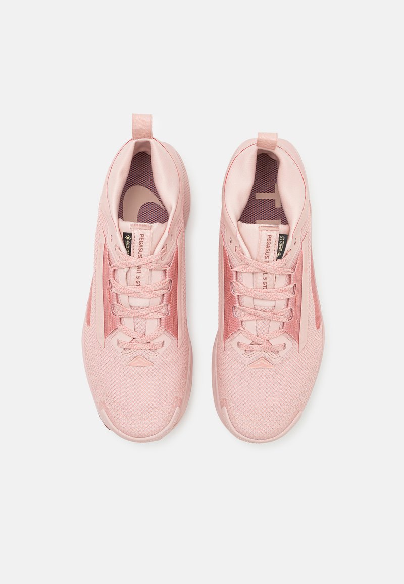 Zapatillas deportivas rosas con parte superior de malla, cierre de cordones y detalles texturizados. Presenta una plantilla acolchada y una lengüeta en el talón.