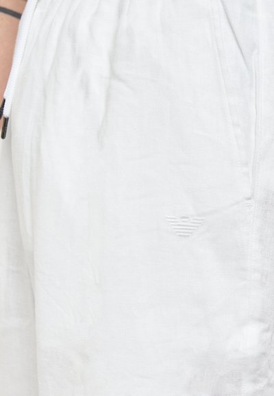 Shorts bianchi in lino con tasche laterali e un sottile dettaglio del logo in rilievo. Finitura texturizzata con una vita elastica per il massimo comfort.
