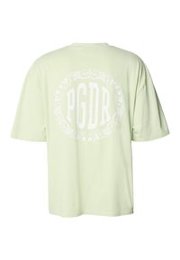 Světle zelené volné bavlněné tričko s krátkými rukávy a bílým grafickým motivem "PGDR" obklopeným květinovým vzorem na zádech.