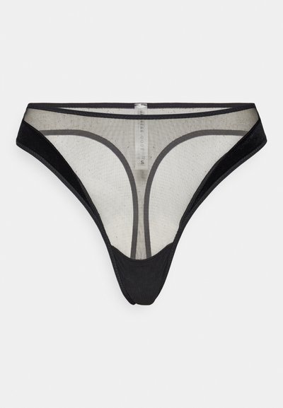 Thong noir en matière transparente. Présente une taille contrastante en noir avec une texture lisse et des coutures minimales. Étiquette visible au centre.