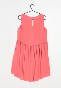 Korallenfarbenes ärmelloses Kleid mit einem ausgestellt geschnittenen Rock, aus glattem Stoff gefertigt. Es hat einen runden Ausschnitt und eine Schlüsselöffnungsdetail auf der Rückseite.