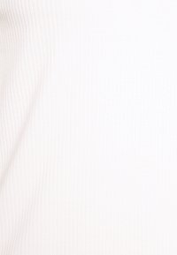 Tissu blanc côtelé présentant une surface fine et texturée. Couleur uniforme sans motifs ni accents visibles. Matière douce.