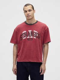 Κόκκινο βαμβακερό μπλουζάκι με στρογγυλή λαιμόκοψη, που φέρει μαύρο γραφικό τύπωμα με τη φράση "STRANGER THINGS" και έχει χαλαρή, άνετη εφαρμογή.